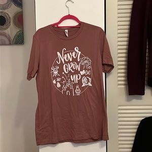 Disney-inspired Never grow up” T-shirt in light red/rosy color.
